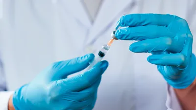 Врач набирает лекарство в шприц